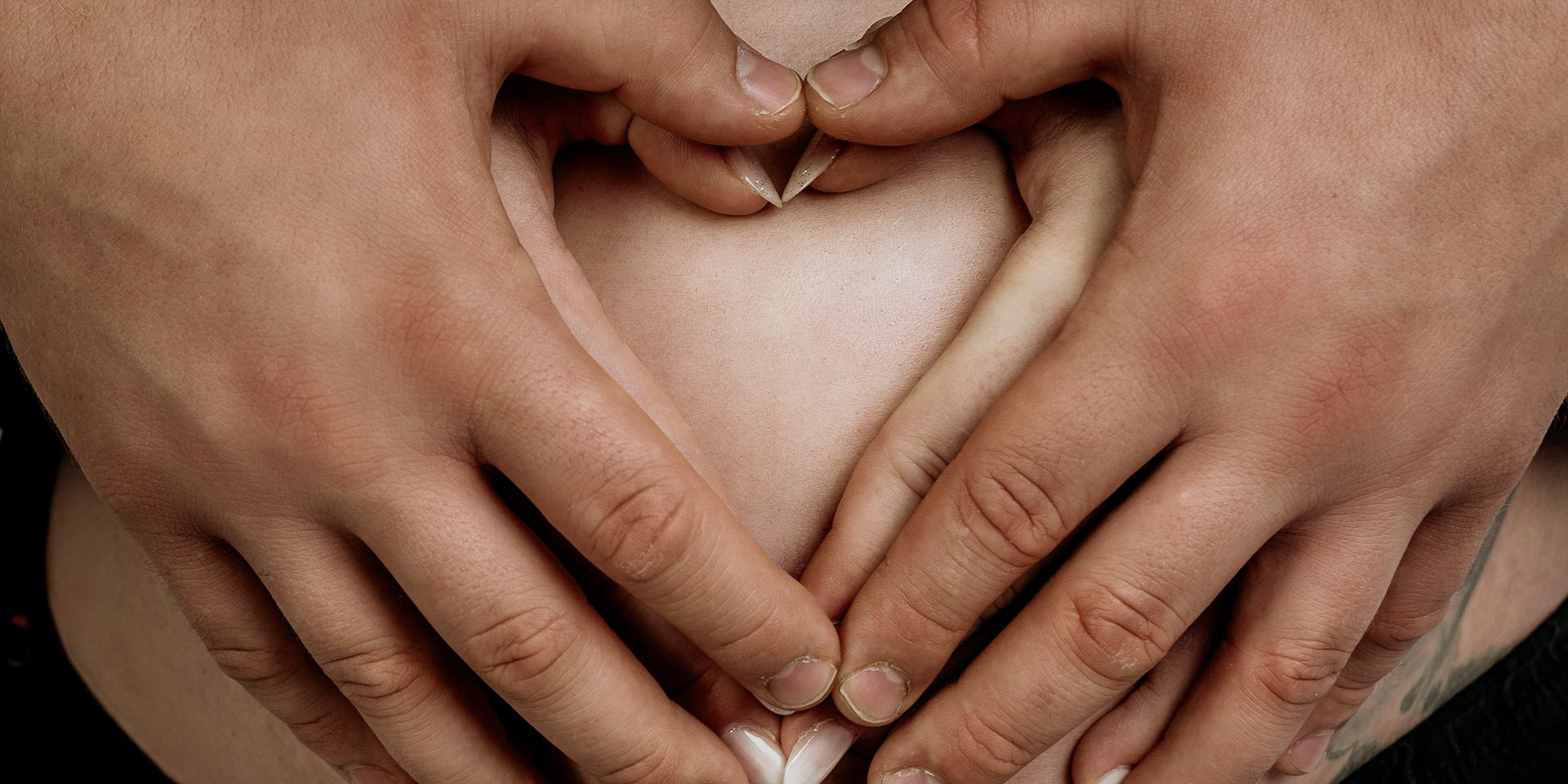 Babybauchshooting – werdende Eltern bei einem emotionalen Studio-Fotoshooting